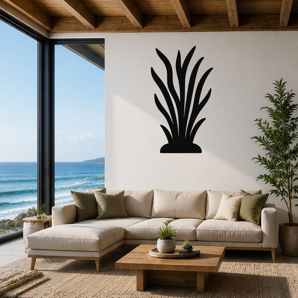 Black metal kelp wall art with leafy cutouts, mounted on a white living room wall above a beige sectional sofa.