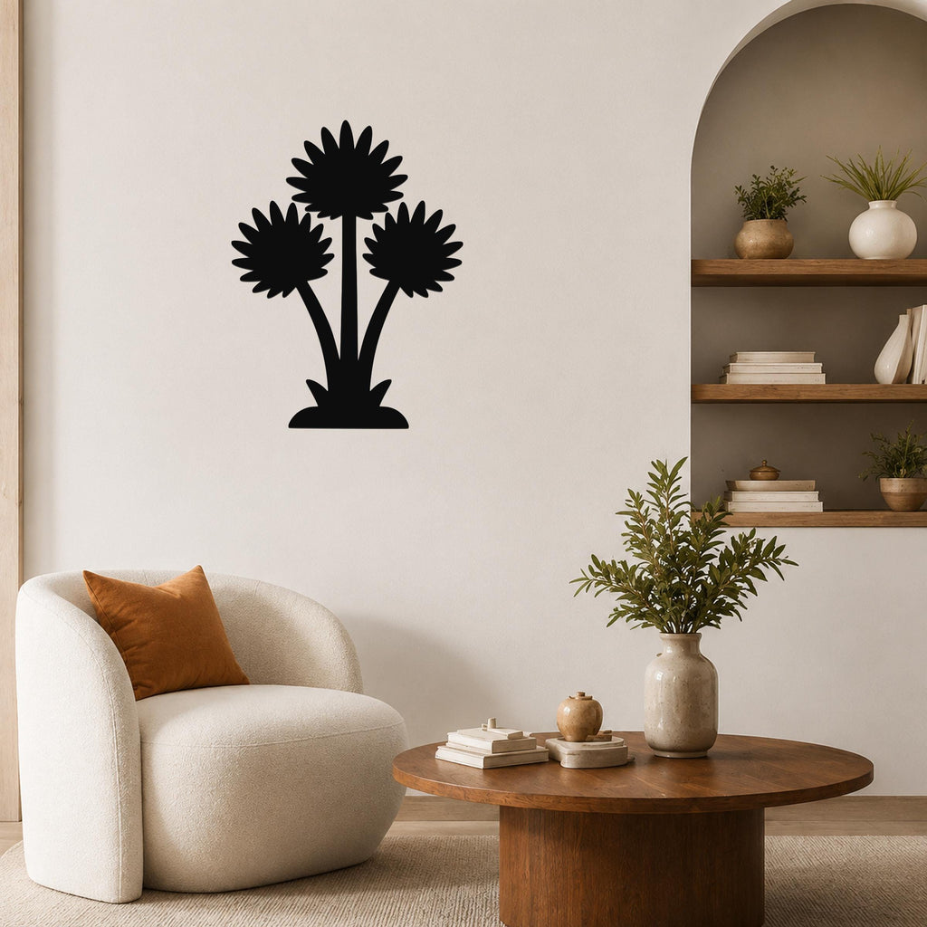 Black metal wall art featuring a silhouette of three wildflowers, mounted on a living room wall above a round wooden coffee table.