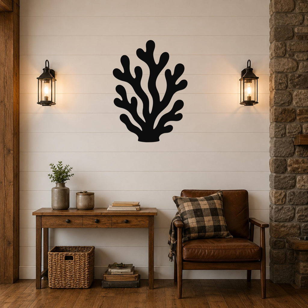 Black metal coral wall art with branching cutouts, mounted on a shiplap wall above a wooden console table in a living room.