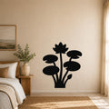 Black metal lotus and water lily wall art silhouette mounted on a beige bedroom wall above a woven rug.