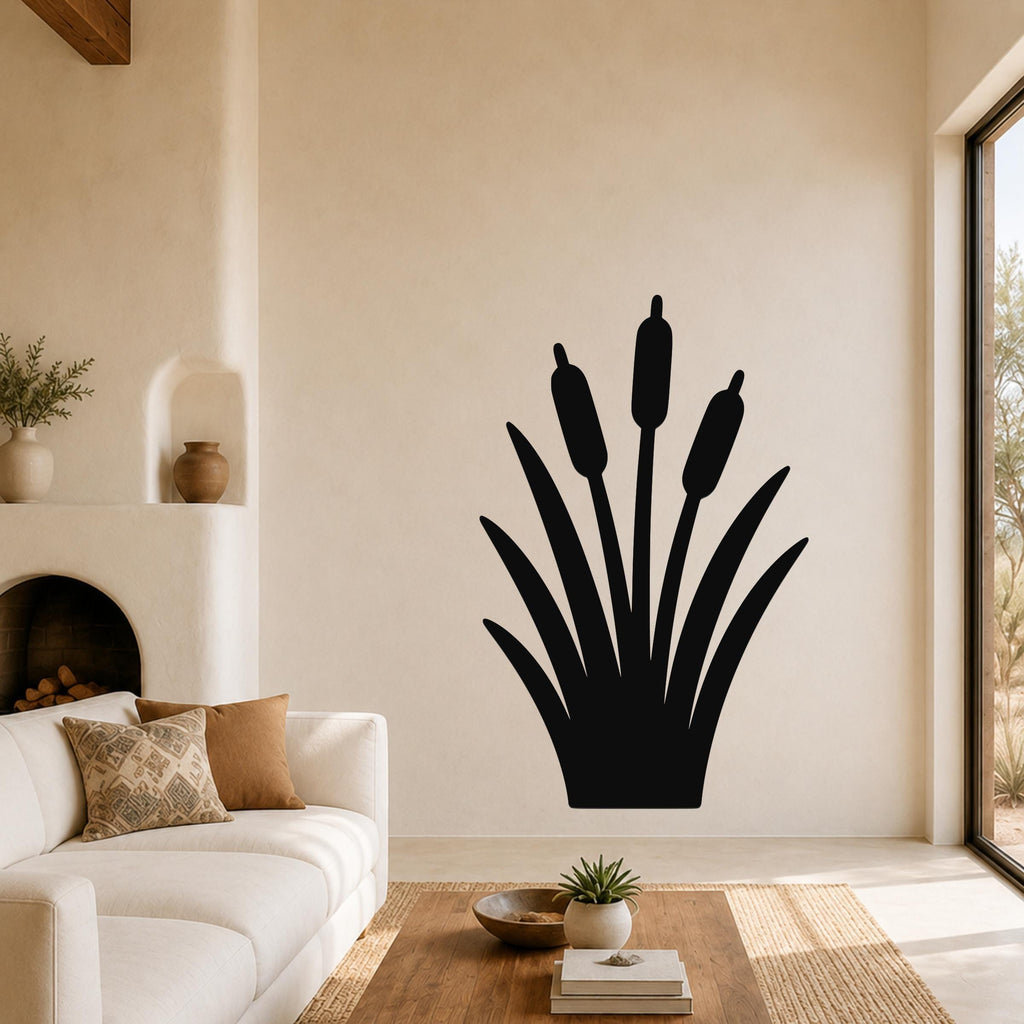 Black metal cattail wall art silhouette with five reeds and long leaves, mounted on a living room wall above a white sofa.