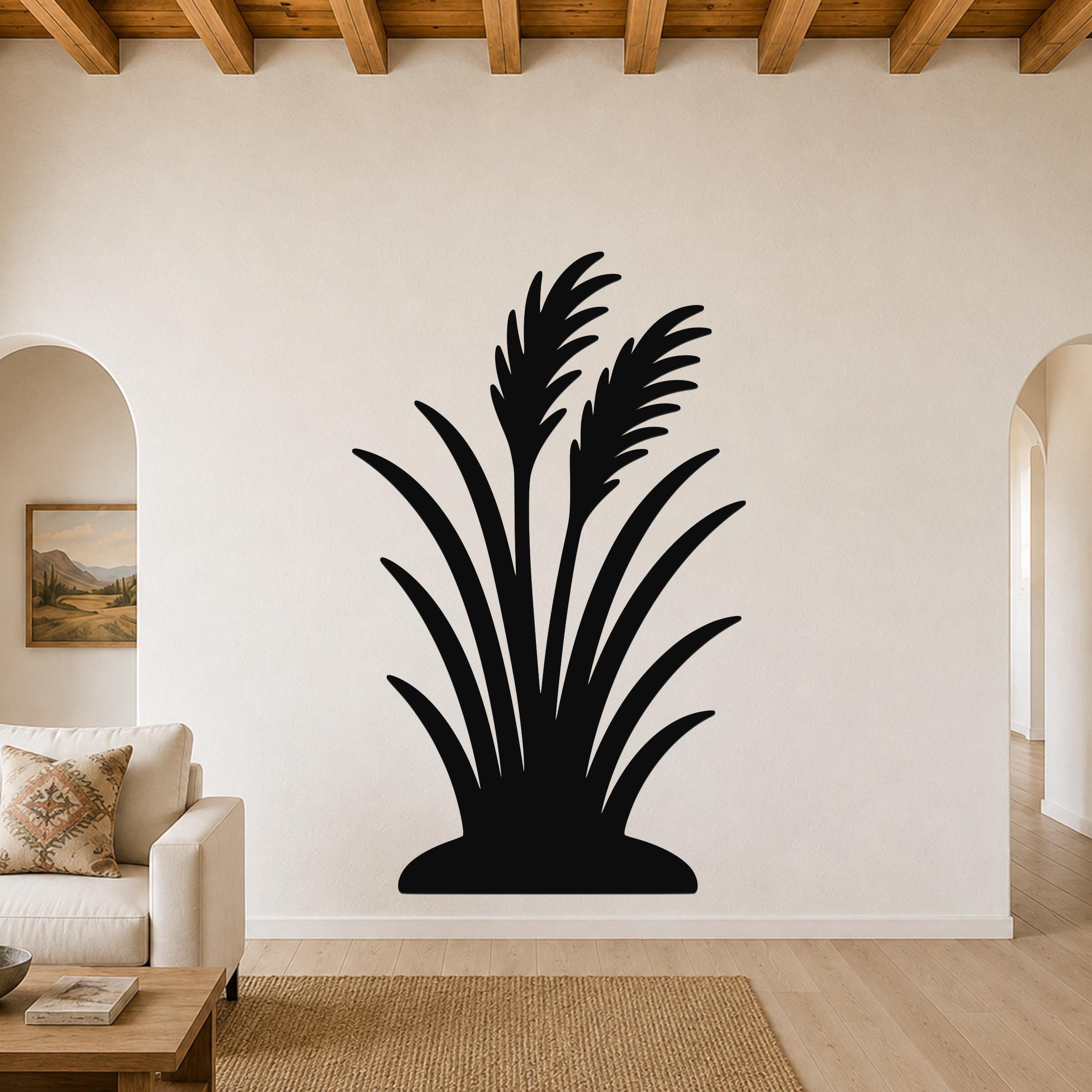 Black metal wall art in a wild grass silhouette design, mounted on a living room wall above a sofa.