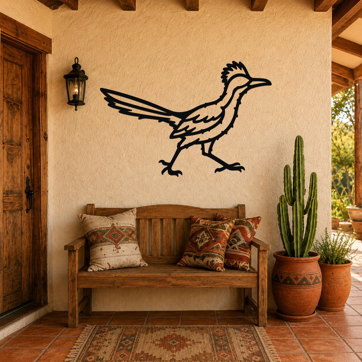 Black metal roadrunner wall art with motion-line cutouts, mounted on a stucco wall above a wooden bench in a patio entryway.
