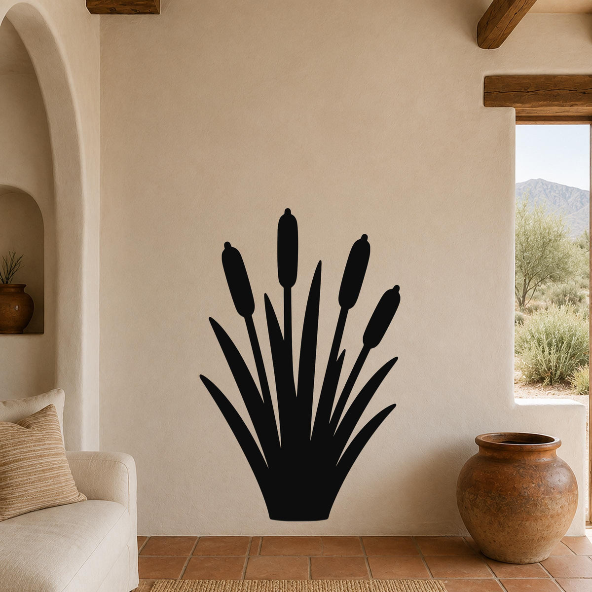 Black metal cattail wall art silhouette with multiple reed stems and seed heads, mounted on a beige living room wall above a sofa.