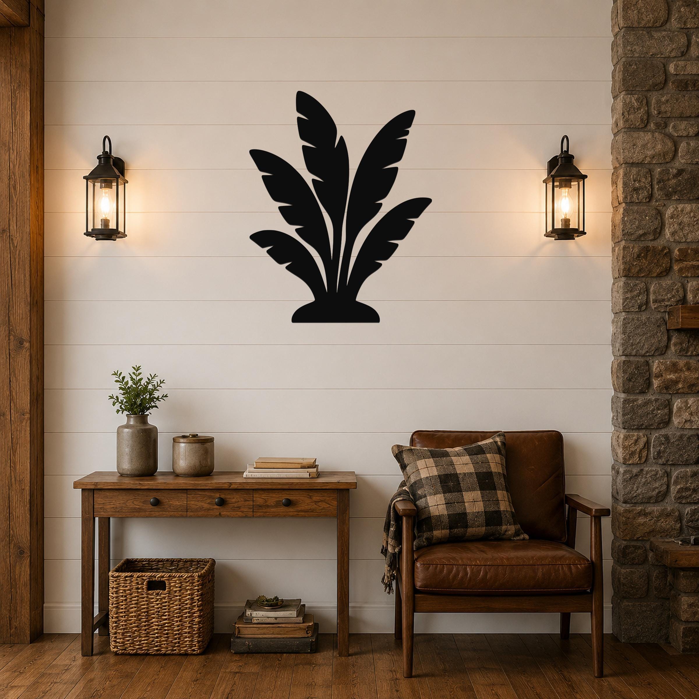 Black metal wall art in a tropical leaf silhouette, mounted on a shiplap wall above a wooden console table in a living room.