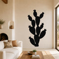 Black metal prickly pear cactus wall art with multiple segmented arms and flower cutouts, mounted on a living room wall above a white sofa.