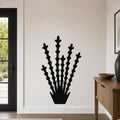 Black metal ocotillo wall art with branching stem cutouts, mounted on a white wall in a modern entryway.