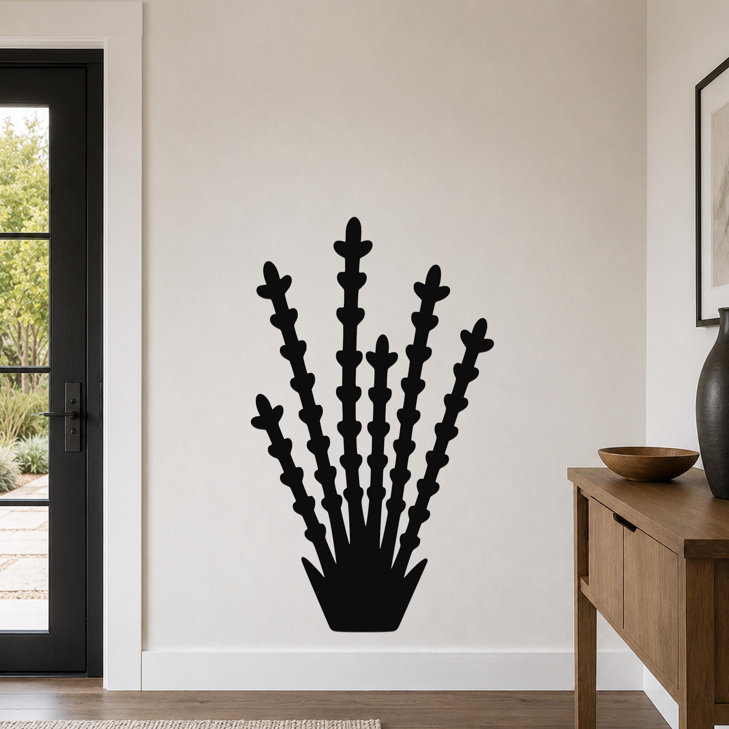 Black metal ocotillo wall art with branching stem cutouts, mounted on a white wall in a modern entryway.