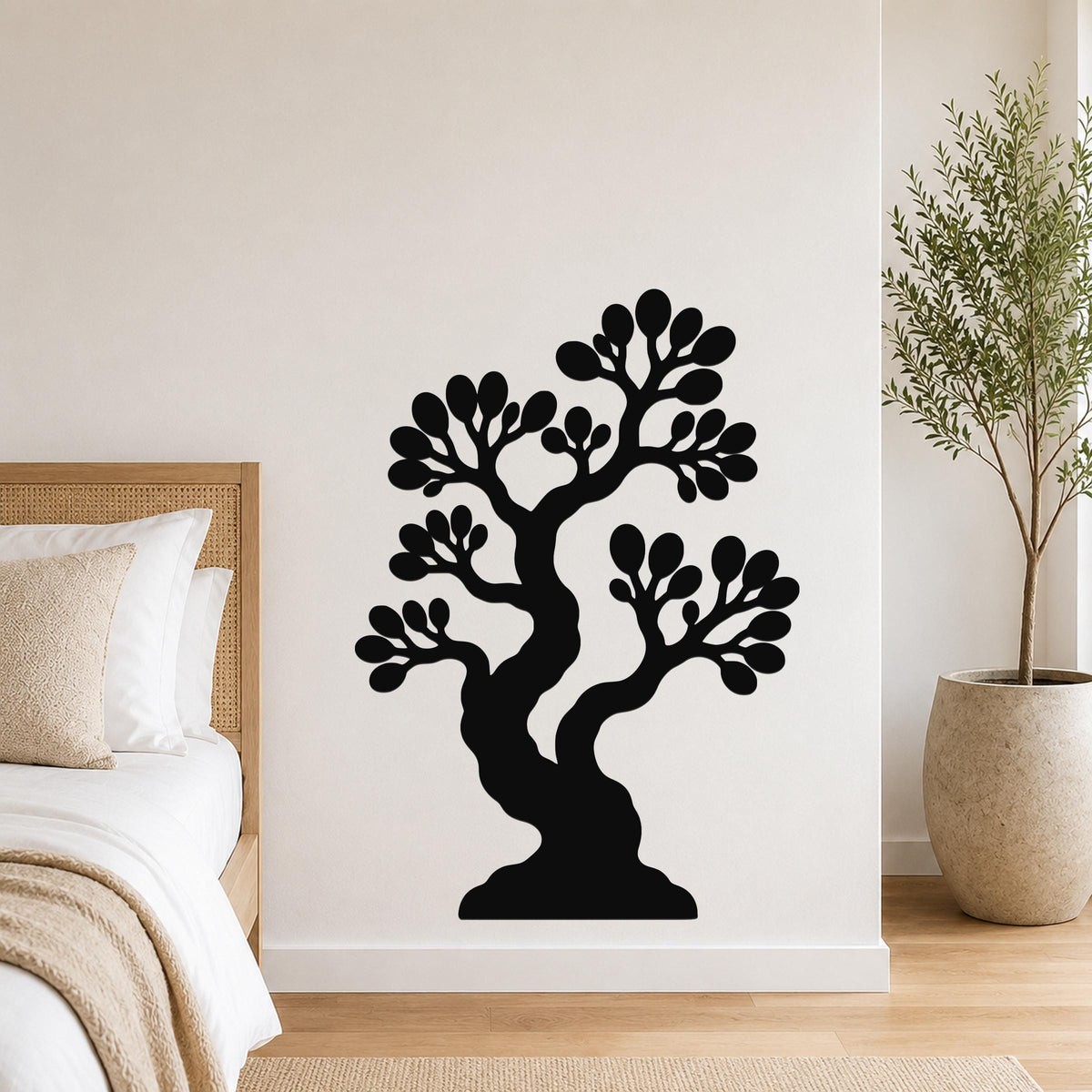 Black metal wall art silhouette of a bonsai tree with layered branches and leaf clusters, mounted on a white bedroom wall above a bed.
