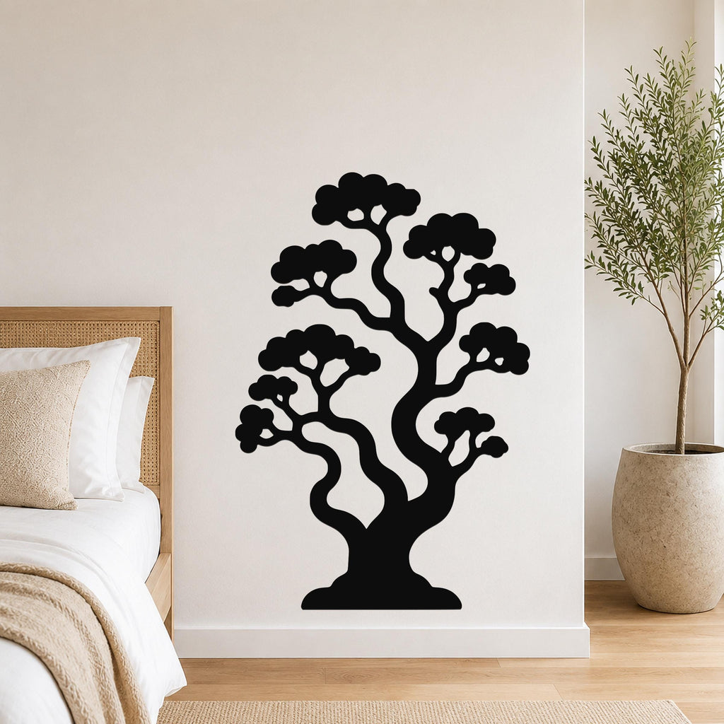Black metal wall art in the silhouette of a bonsai tree with curved branches and cloud-like foliage, mounted on a white wall above a bed in a bedroom.