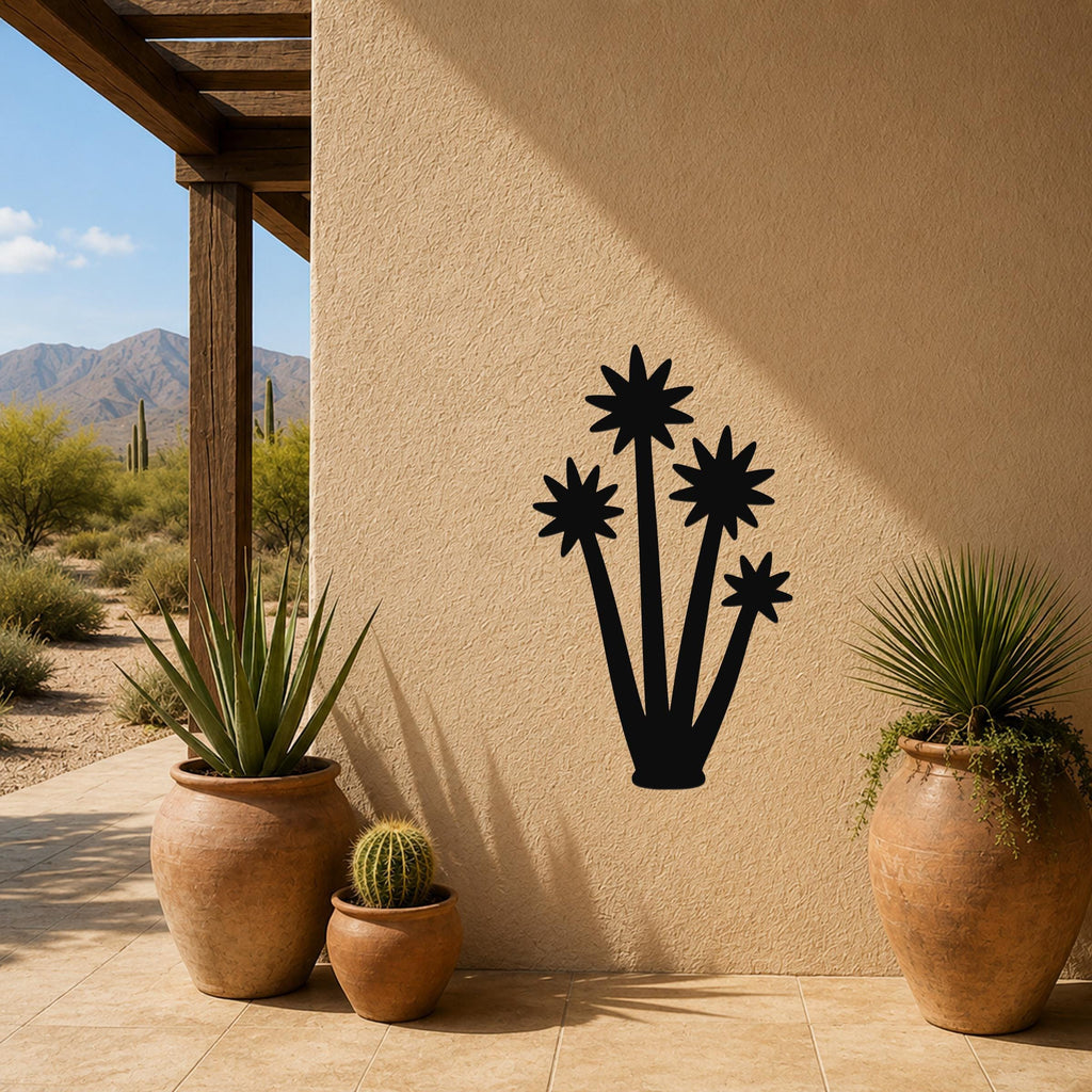 Black metal yucca wall art with star-shaped bloom cutouts, mounted on a stucco outdoor wall above potted plants on a patio.