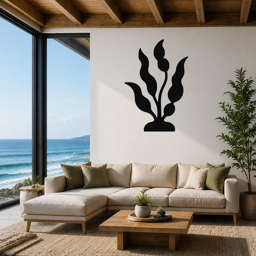 Black metal kelp wall art with flowing leaf cutouts, mounted on a white living room wall above a beige sectional sofa.