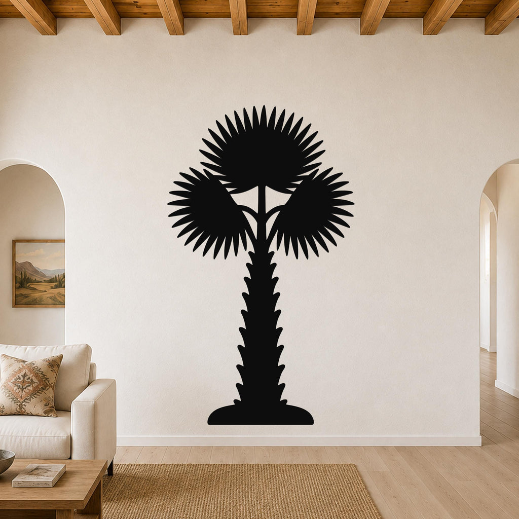 Black metal palm tree wall art with fan-shaped fronds and a textured trunk, mounted on a living room wall above a sofa.