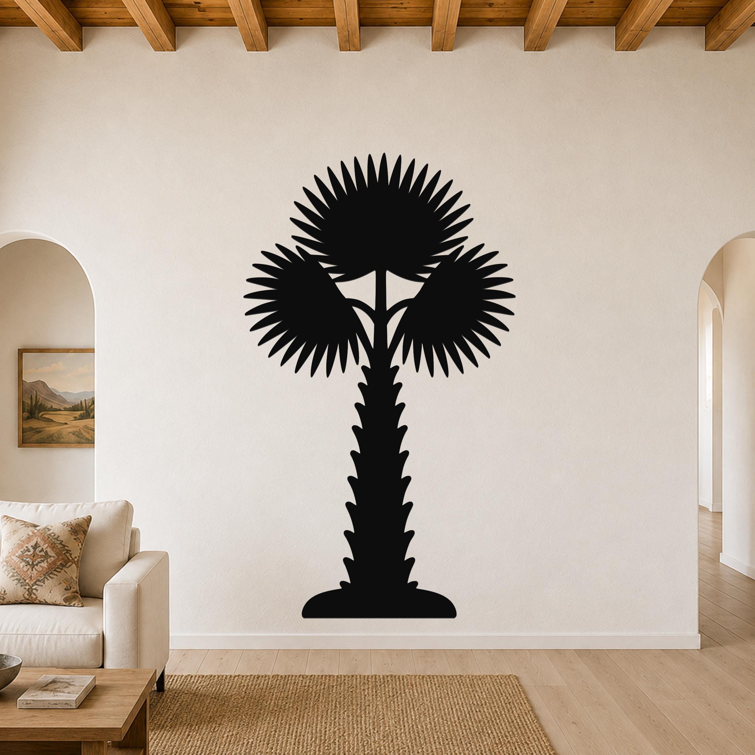 Black metal palm tree wall art with fan-shaped fronds and a textured trunk, mounted on a living room wall above a sofa.