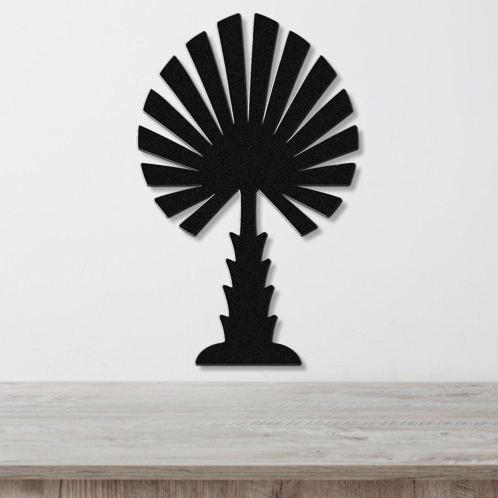 Black metal palm tree wall art with fan-shaped fronds and a textured trunk, mounted on a white wall above a light wood countertop.
