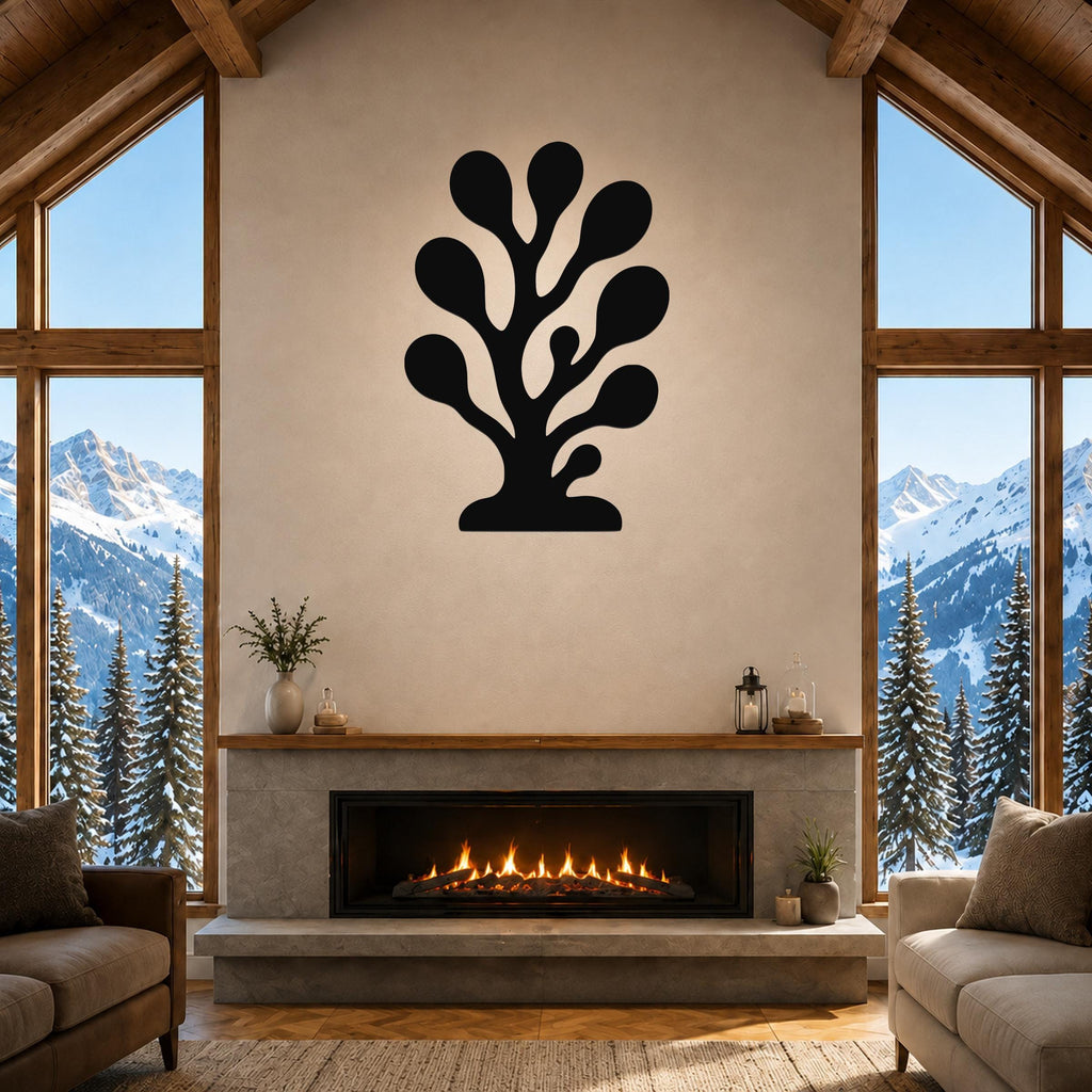 Black metal coral wall art with organic branch cutouts, mounted above a fireplace in a living room with large windows and mountain views.