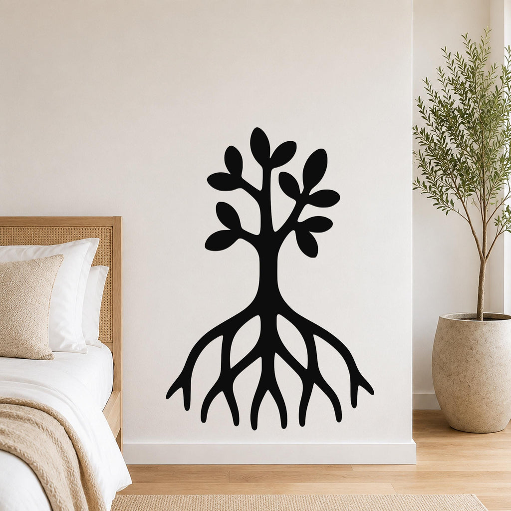 Black metal wall art in a tree silhouette with visible roots and leafy branches, mounted on a white bedroom wall above a bed.