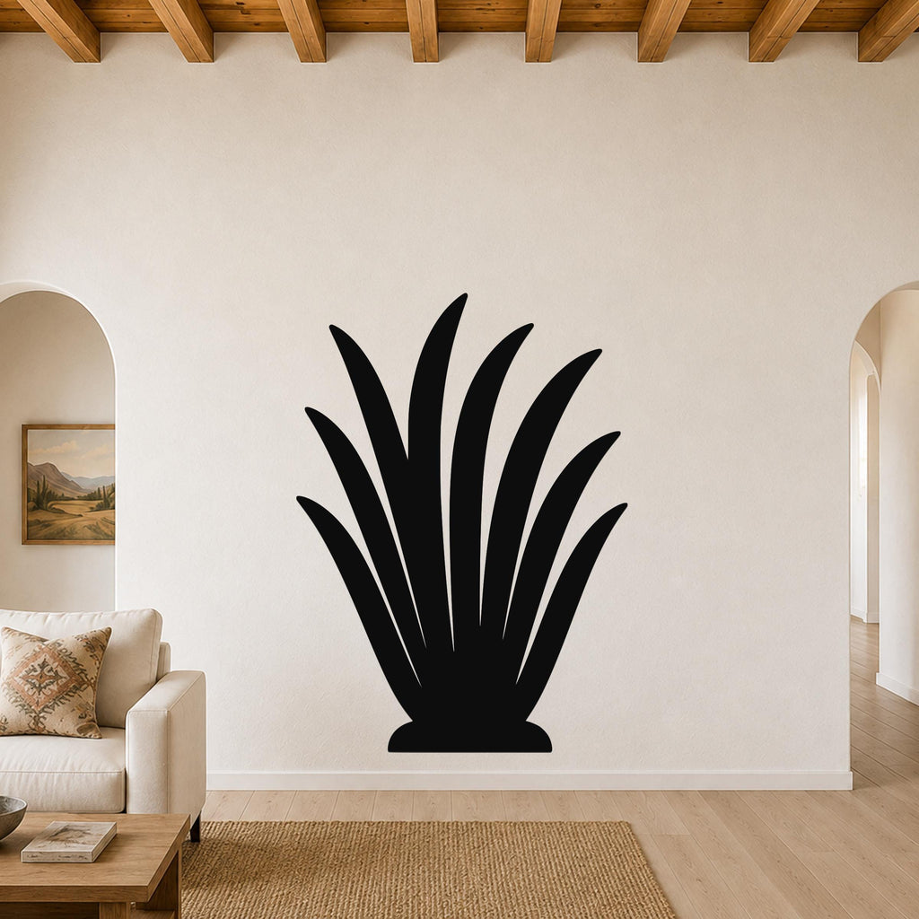 Black metal agave plant wall art with leaf cutouts, mounted on a living room wall above a sofa.