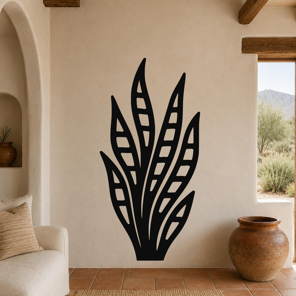 Black metal wall art in a snake plant silhouette with internal cutout details, mounted on a beige living room wall above a sofa.