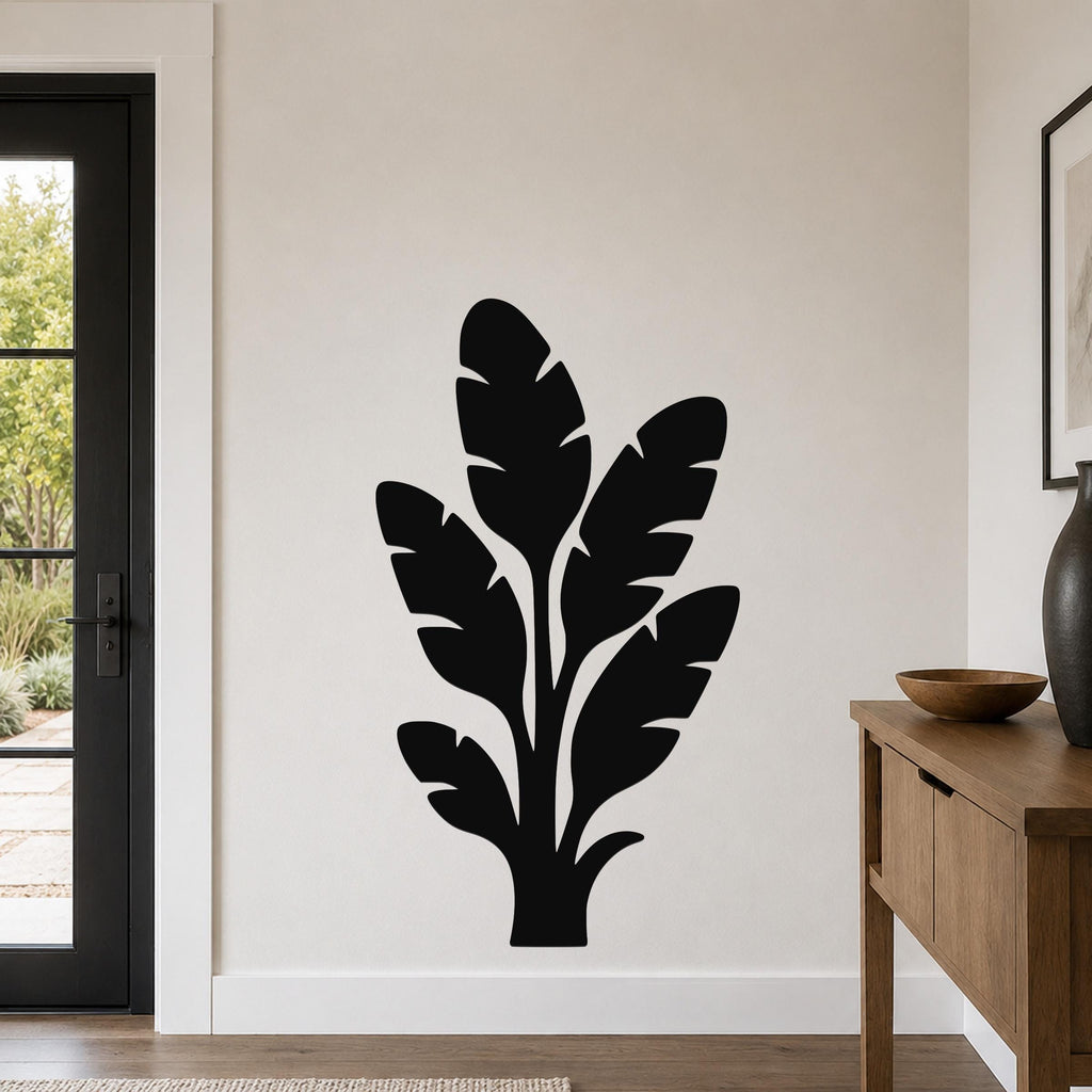 Black metal wall art featuring a tropical leaf silhouette, mounted on a living room wall above a wooden console table.