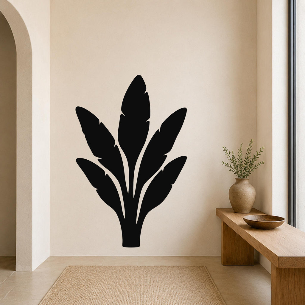 Black metal wall art in a banana leaf silhouette design, mounted on a beige wall above a wooden bench in a minimalist entryway.