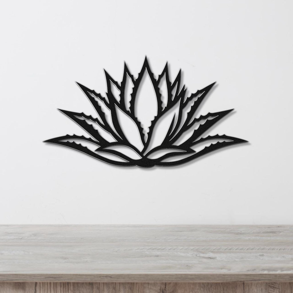 Black metal agave wall art with a bold geometric cutout design, mounted on a white wall above a light wood counter.