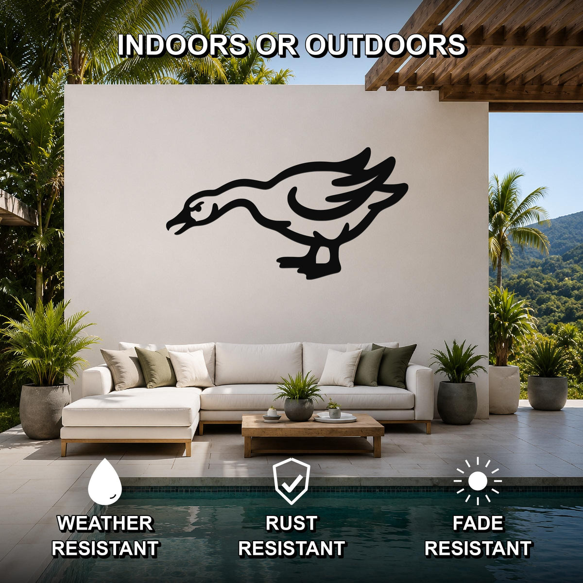 Black metal goose wall art with motion-line cutouts, mounted on a white outdoor wall above a sofa in a patio living area.