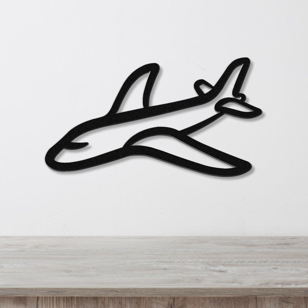 Black metal airplane wall art with a sleek silhouette design, mounted on a white wall above a light wood countertop.
