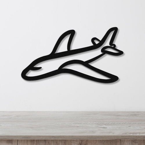 Black metal airplane wall art with a sleek silhouette design, mounted on a white wall above a light wood countertop.
