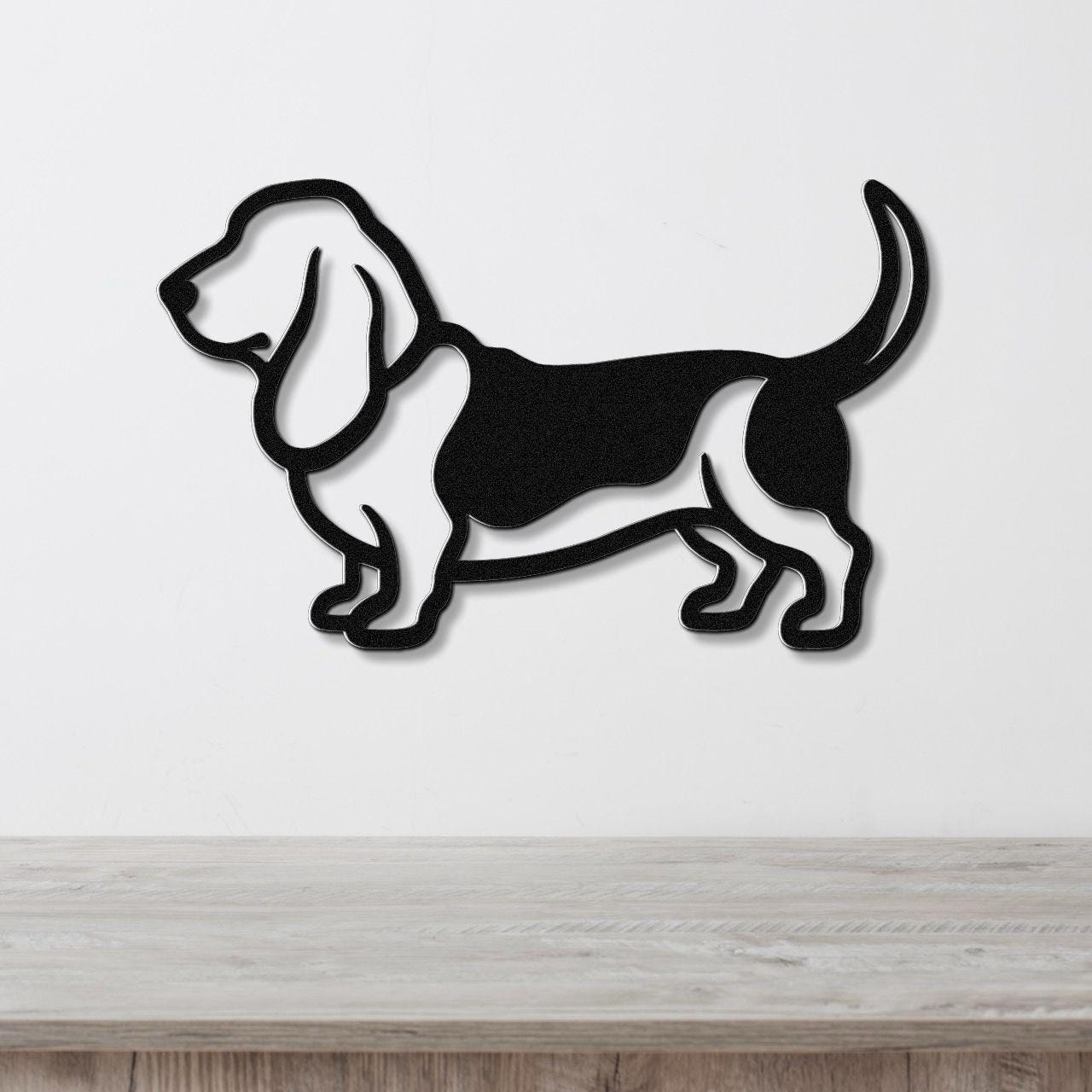 Black metal wall art silhouette of a basset hound, mounted on a white wall above a light wood surface.
