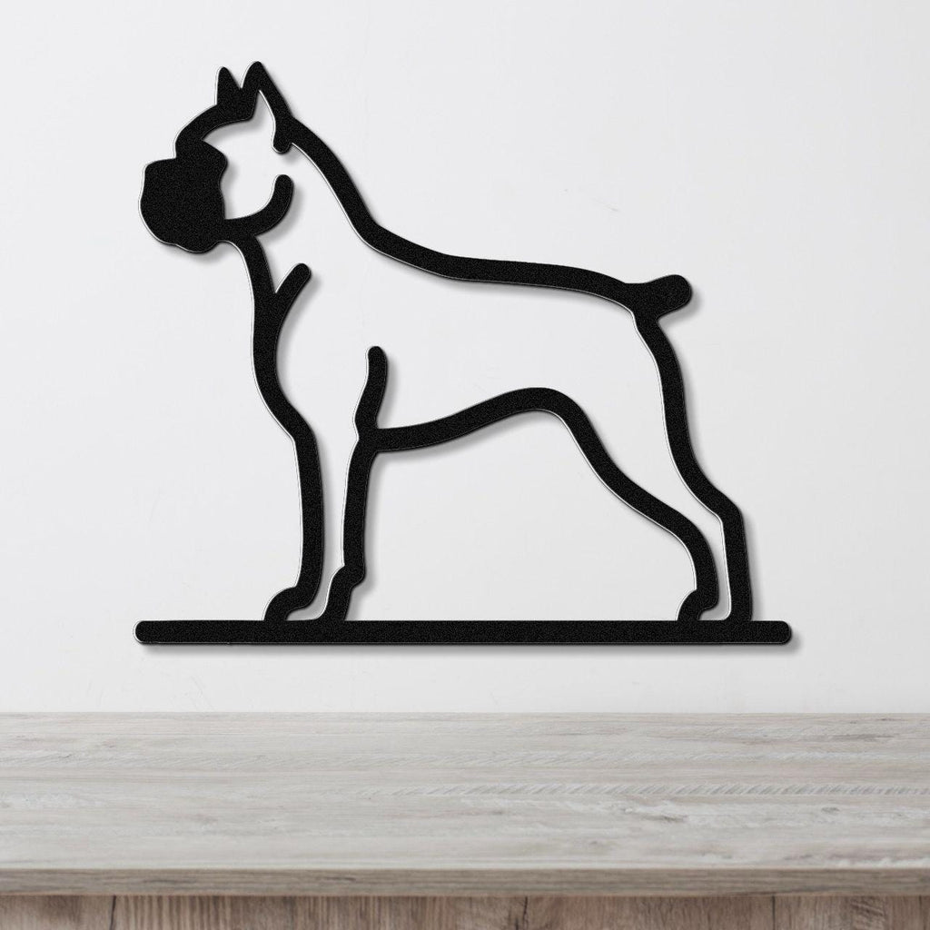 Black metal silhouette wall art of a standing boxer dog, mounted on a white wall above a light wood surface.