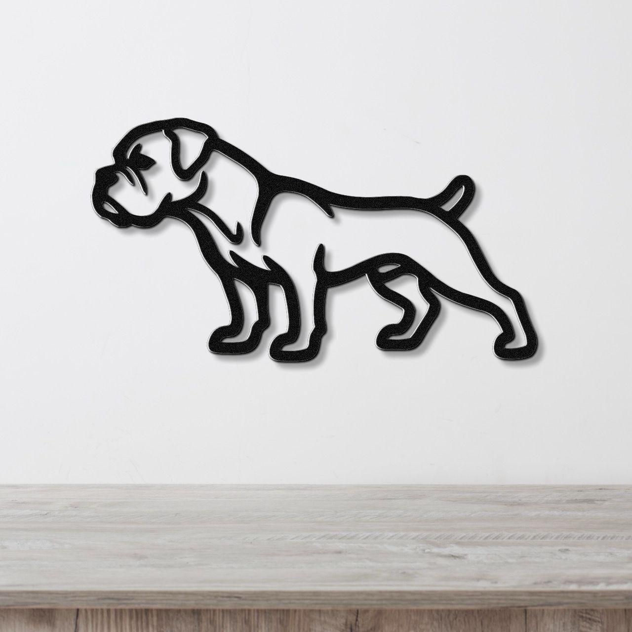 Black metal wall art featuring a bold silhouette of a boxer dog, mounted on a white wall above a light wood surface.