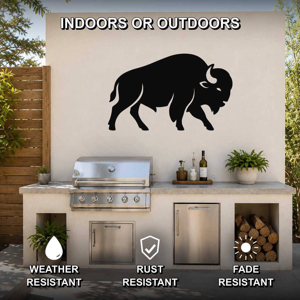 Black metal buffalo silhouette wall art mounted on an outdoor kitchen wall above a stainless steel grill, with visible weather, rust, and fade resistance icons.