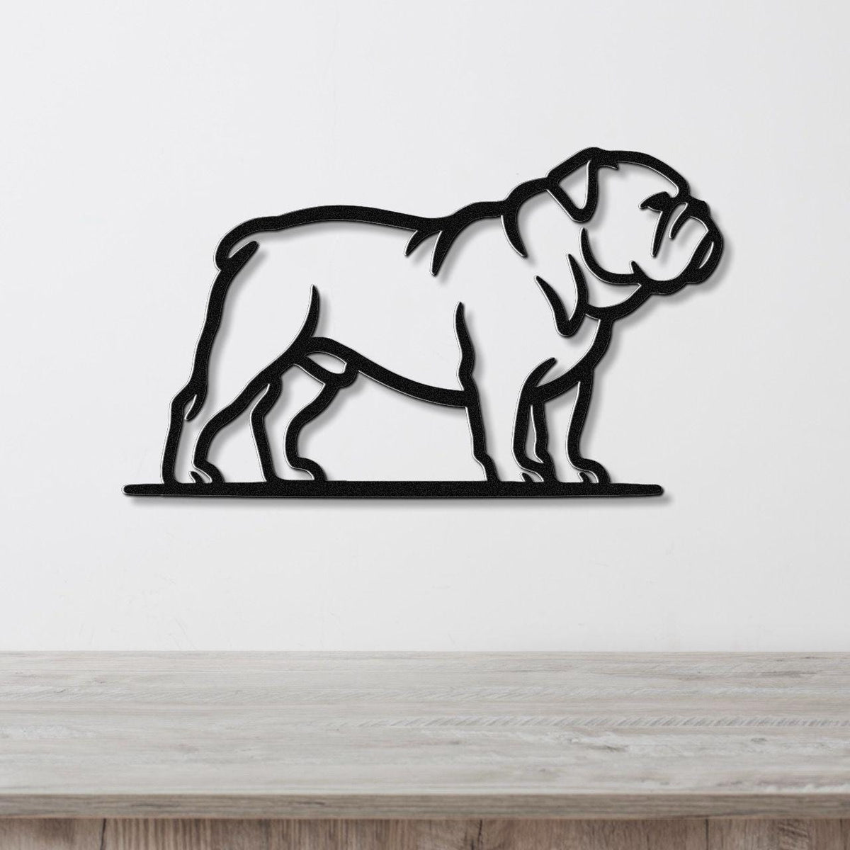 Black metal bulldog wall art with a bold silhouette and internal cutout details, mounted on a white wall above a light wood countertop.