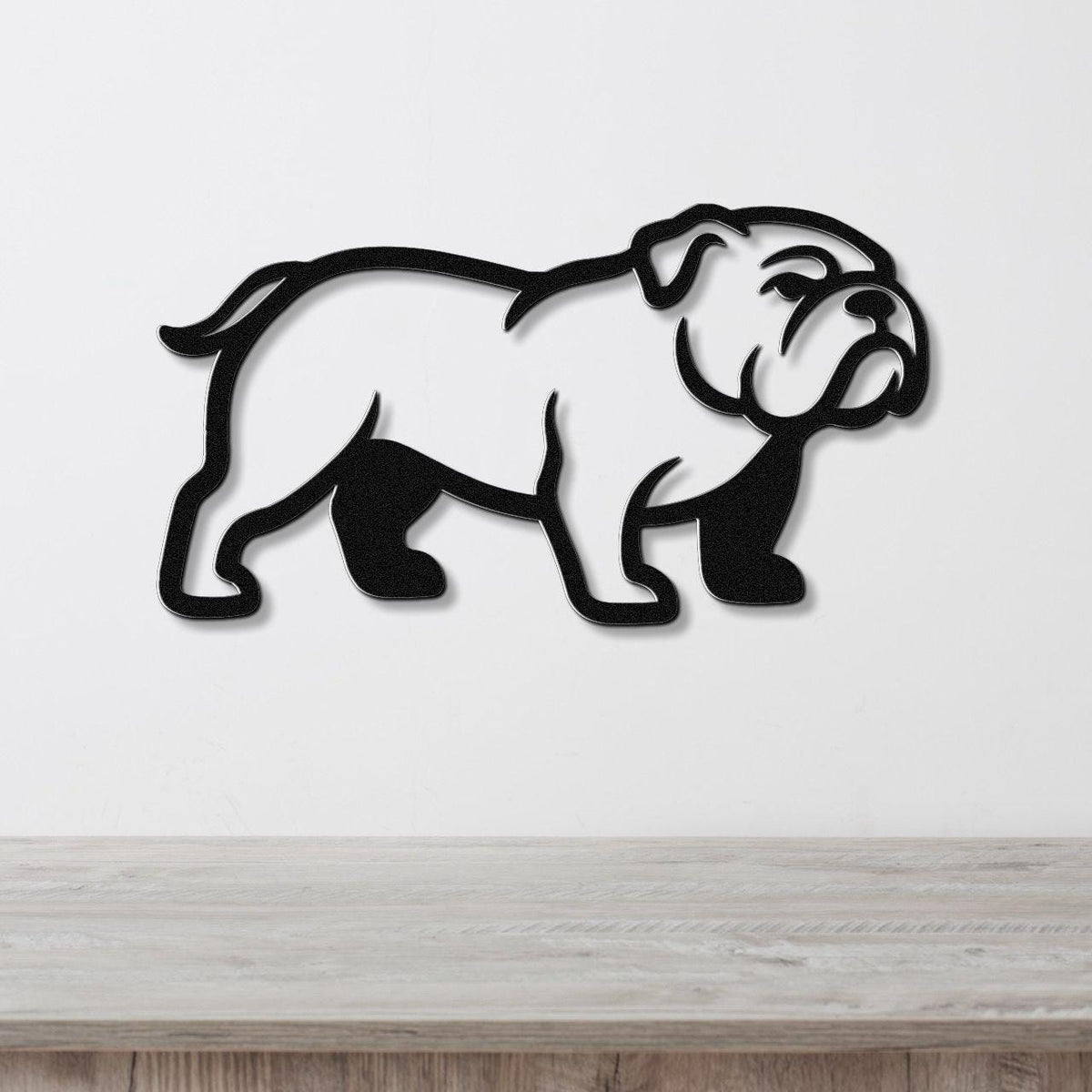 Black metal bulldog wall art silhouette with cutout details, mounted on a white wall above a light wood counter.