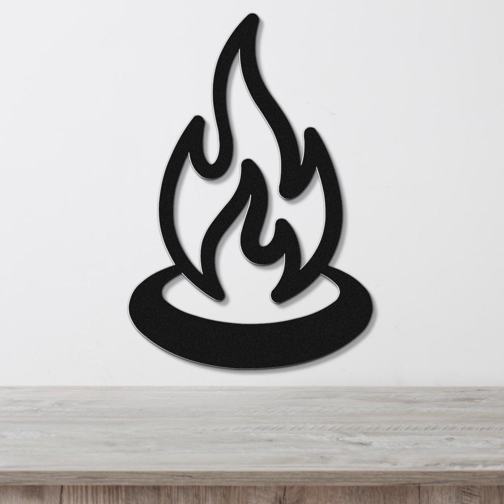 Black metal wall art in a flame silhouette design, mounted on a white wall above a light wood surface.