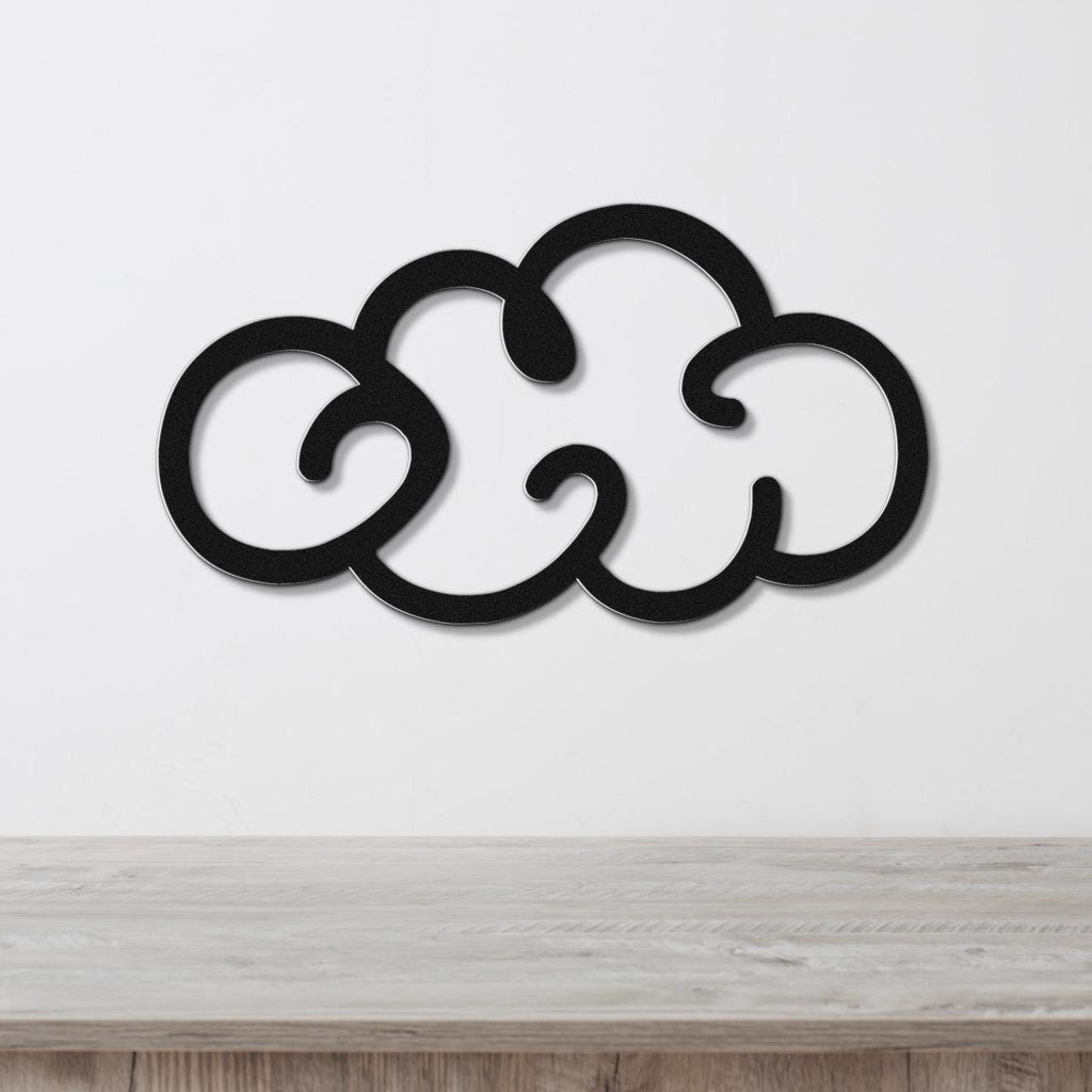 Black metal cloud wall art with a cutout design, mounted on a white wall above a wooden surface.