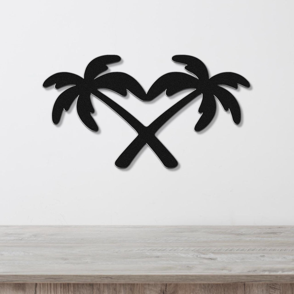 Black metal wall art featuring two crossed palm trees forming a heart shape, mounted on a white wall above a wooden surface.