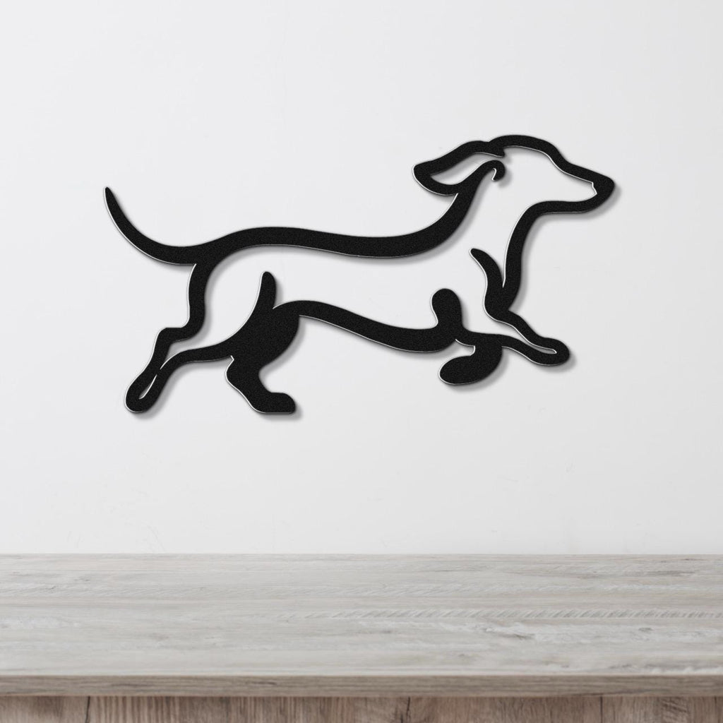 Black metal dachshund wall art with a running silhouette, mounted on a white wall above a light wood counter.
