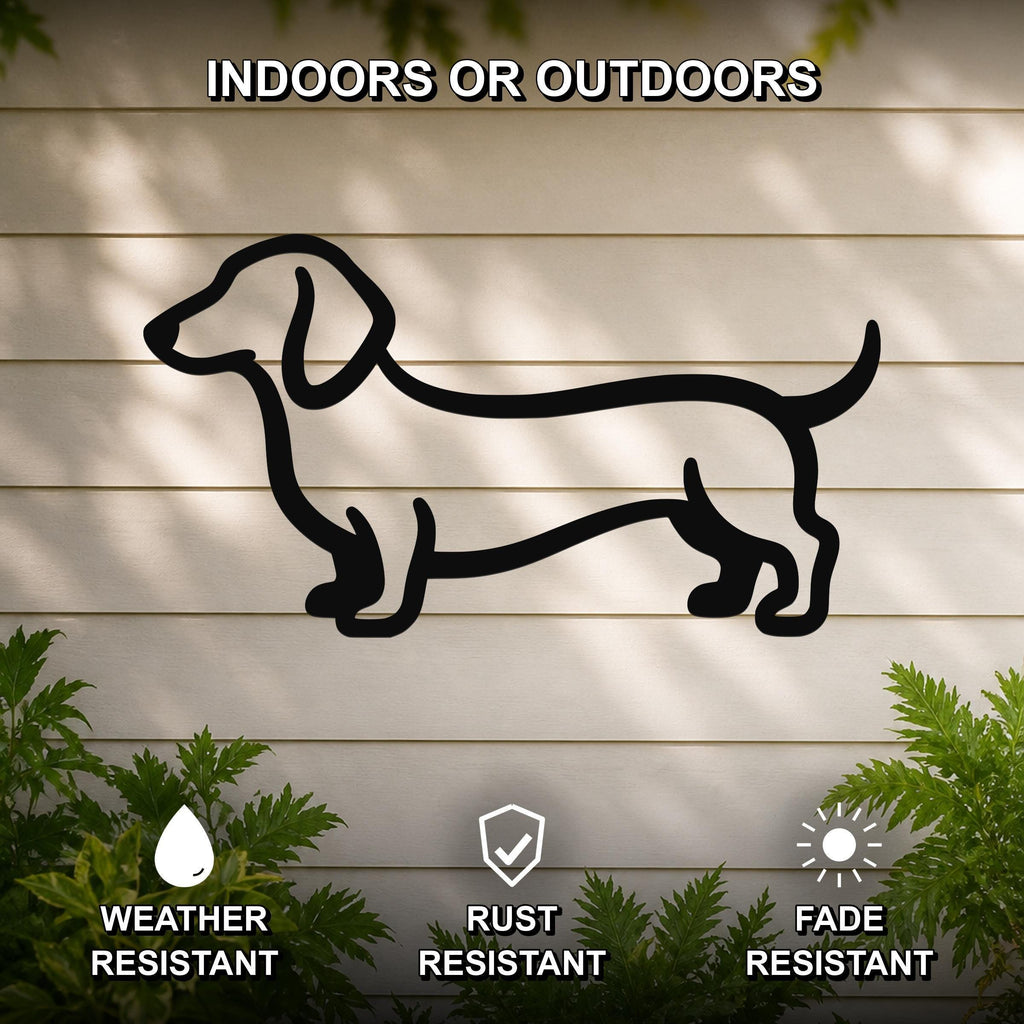 Black metal dachshund wall sculpture in silhouette, mounted on a light-colored outdoor wall with greenery, weather resistant, rust resistant, and fade resistant.