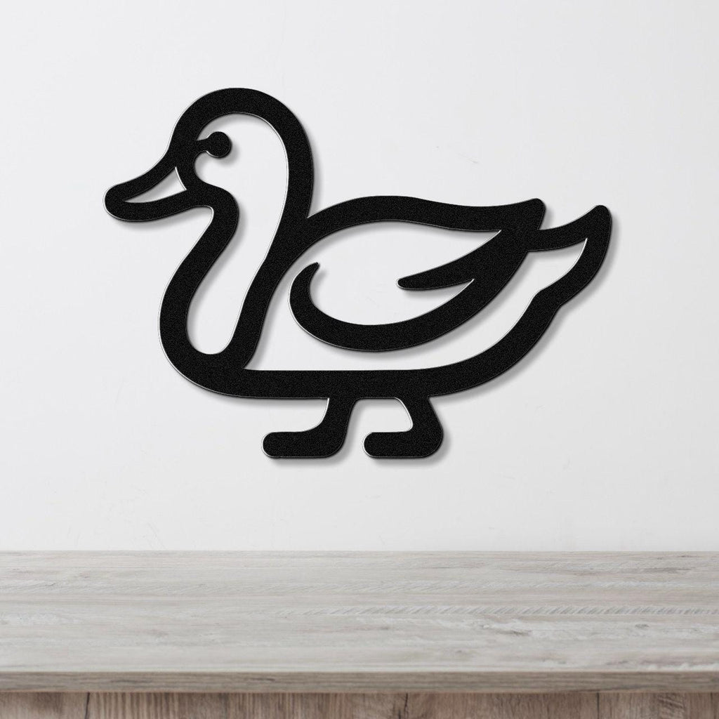 Black metal duck wall art with a cutout silhouette design, mounted on a white wall above a light wood countertop.