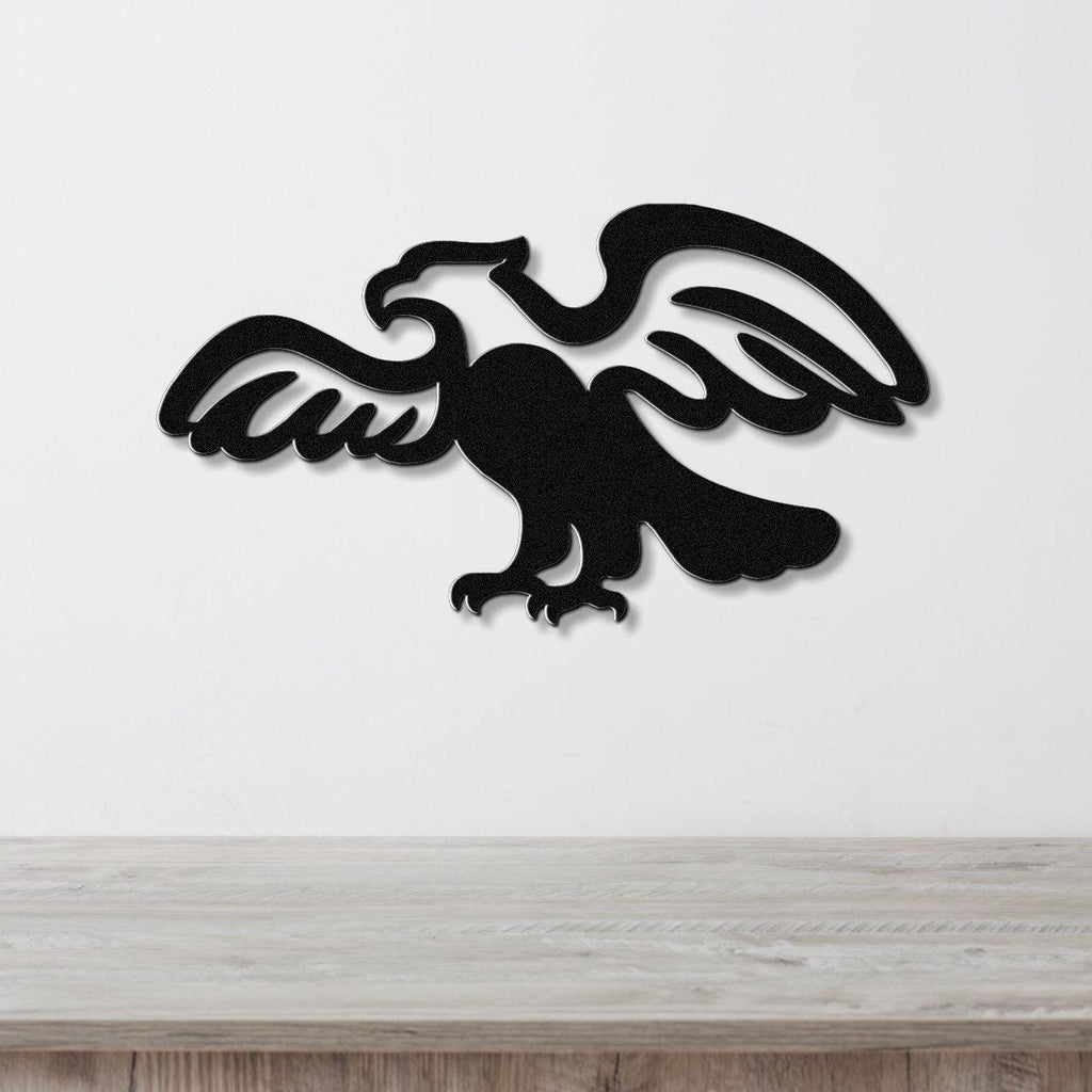 Black metal eagle wall art with outstretched wings and detailed feather cutouts, mounted on a white wall above a light wood countertop.