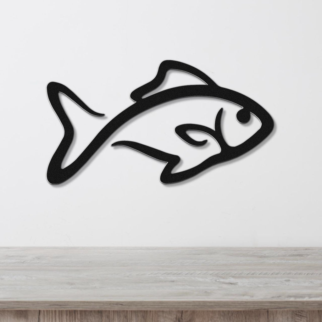 Black metal fish wall art with a silhouette design, mounted on a white wall above a light wood surface.