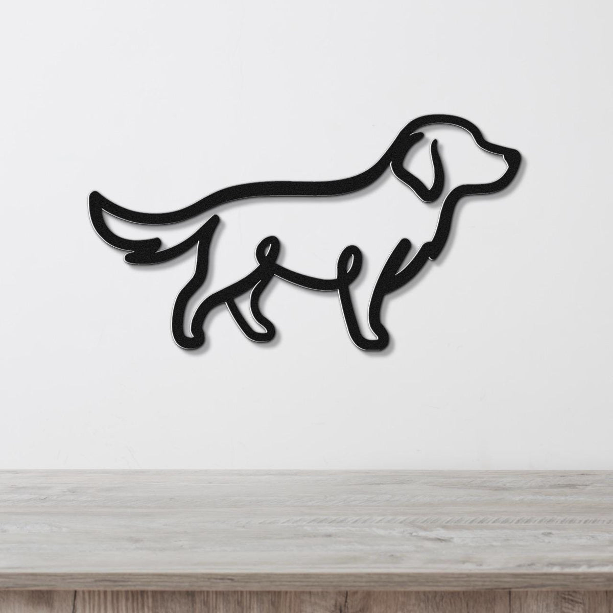 Black metal wall art in the silhouette of a dog, mounted on a white wall above a light wood surface.