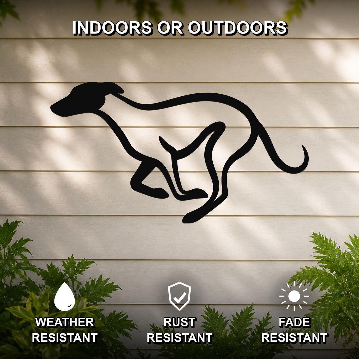 Black metal greyhound wall art silhouette with motion-line cutouts, mounted on a light-colored outdoor wall with greenery below.