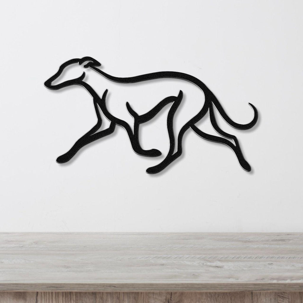 Black metal greyhound wall art with motion-line cutouts, mounted on a white wall above a light wood surface.