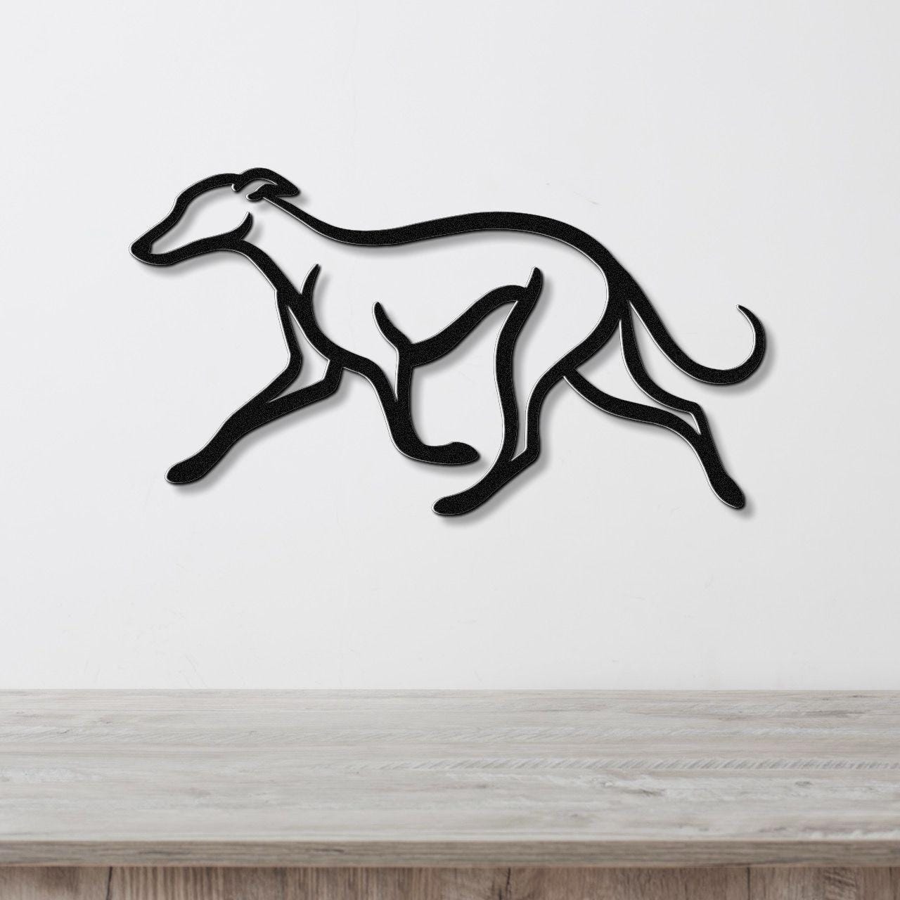 Black metal greyhound wall art with motion-line cutouts, mounted on a white wall above a light wood surface.