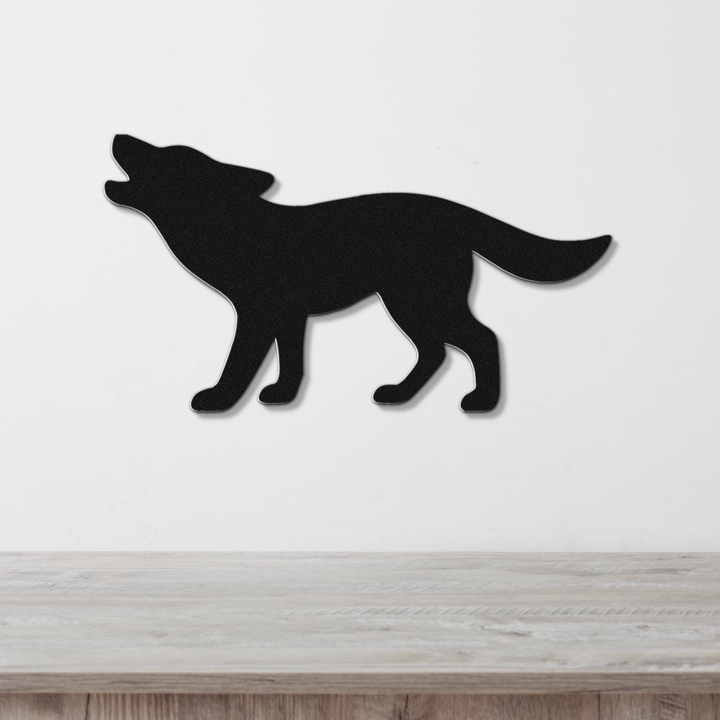 Black metal coyote wall art in a howling silhouette, mounted on a white wall above a light wood surface.