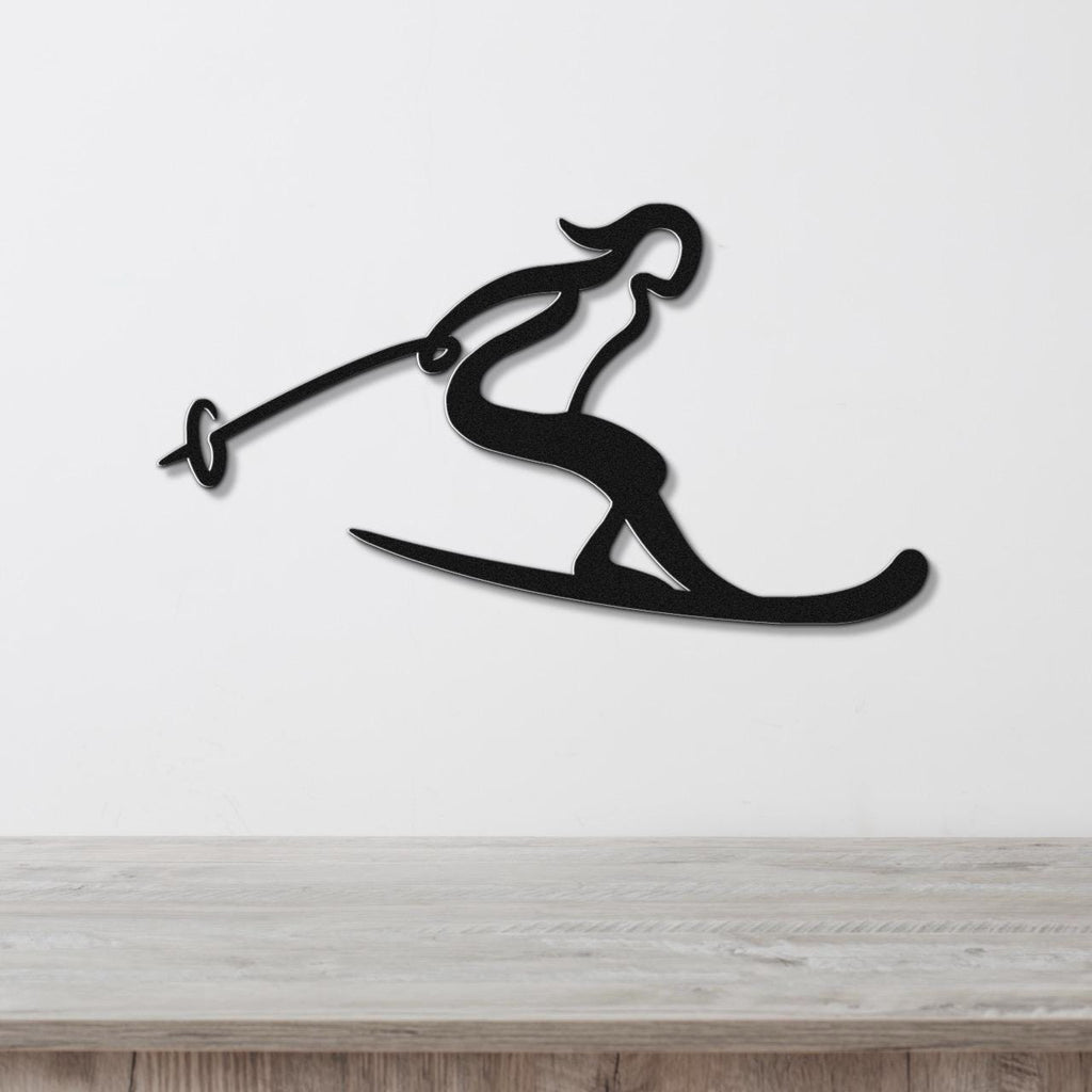 Black metal wall art of a skier silhouette with ski poles and skis, mounted on a white wall above a wooden surface.