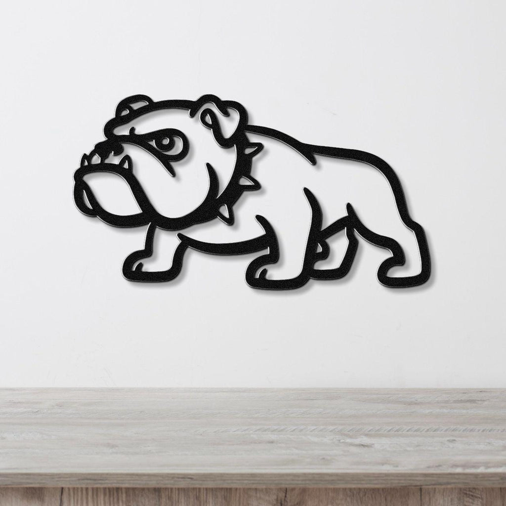 Black metal bulldog wall sculpture with bold silhouette and internal cutout details, mounted on a white wall above a light wood surface.